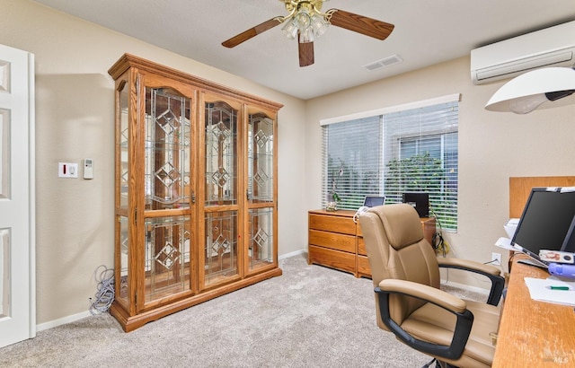 home office featuring light carpet, baseboards, visible vents, a ceiling fan, and an AC wall unit