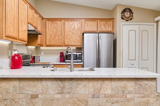 kitchen featuring stainless steel appliances, lofted ceiling, under cabinet range hood, and light stone counters