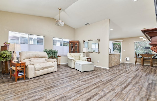 living room featuring light wood-style flooring, recessed lighting, visible vents, baseboards, and vaulted ceiling