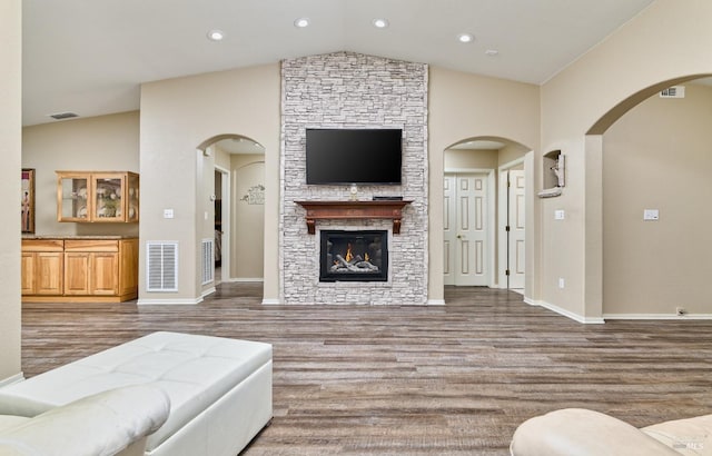 living area with a fireplace, wood finished floors, and visible vents