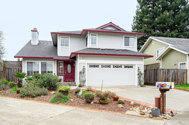 traditional home featuring an attached garage, a shingled roof, fence, driveway, and a chimney