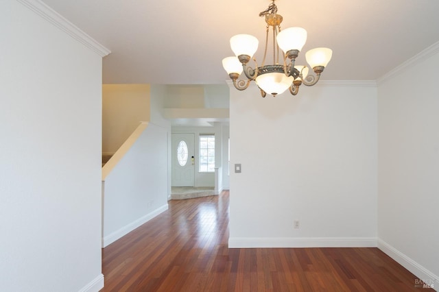 interior space with baseboards, ornamental molding, a chandelier, and wood finished floors