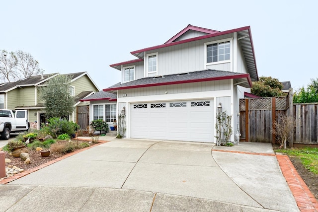 traditional-style house with a garage, concrete driveway, and fence