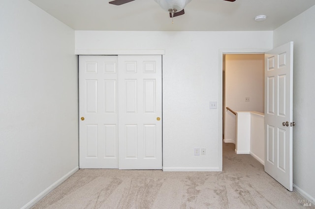 unfurnished bedroom with carpet floors, ceiling fan, baseboards, and a closet