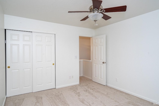 unfurnished bedroom with a ceiling fan, carpet, a closet, and baseboards