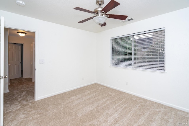 unfurnished room featuring light colored carpet, ceiling fan, visible vents, and baseboards