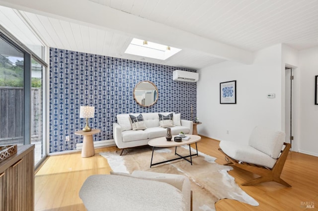 living room with a skylight, beam ceiling, an AC wall unit, and wood finished floors