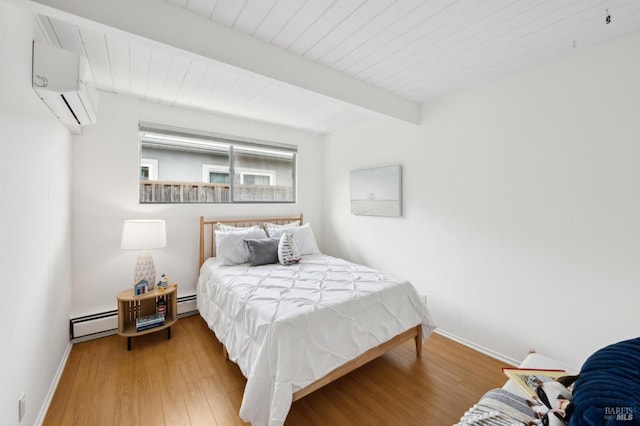 bedroom featuring a baseboard heating unit, wood finished floors, an AC wall unit, and beamed ceiling