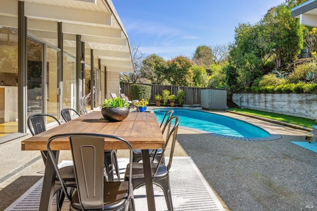 view of swimming pool featuring outdoor dining space, a fenced backyard, a fenced in pool, and a patio