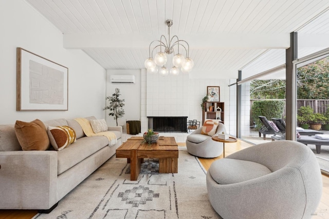 living area with floor to ceiling windows, a notable chandelier, light wood-style flooring, a tiled fireplace, and an AC wall unit