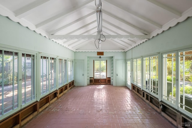 unfurnished sunroom featuring lofted ceiling with beams