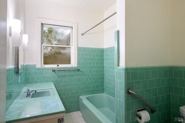 full bathroom with shower / tub combination, tile patterned flooring, vanity, tile walls, and wainscoting