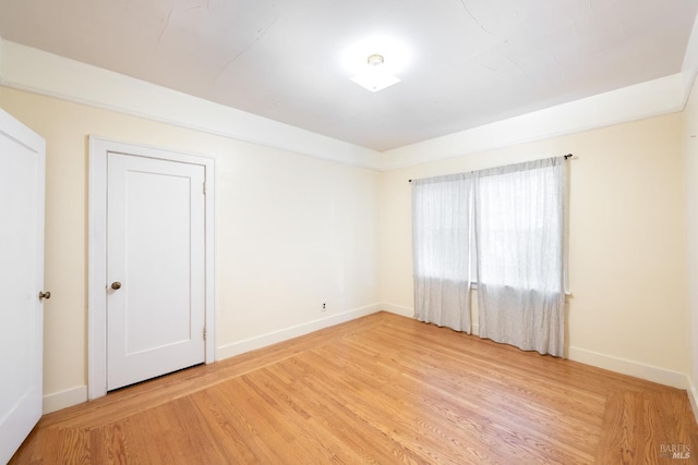 empty room featuring light wood-style flooring and baseboards