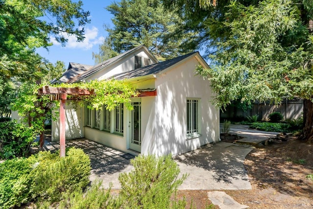 exterior space featuring a patio, fence, and stucco siding