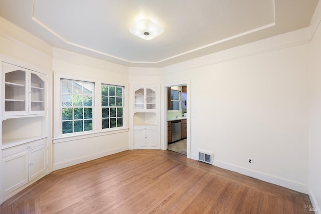 unfurnished room featuring light wood-style floors, baseboards, and visible vents