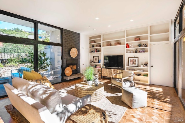 living room featuring built in features, a large fireplace, and floor to ceiling windows