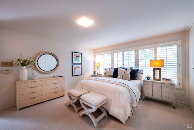 bedroom with light carpet and baseboards