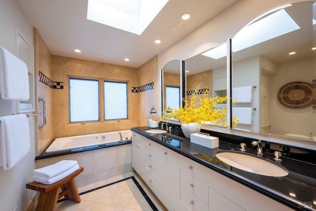 bathroom with a bath, a skylight, a sink, and recessed lighting