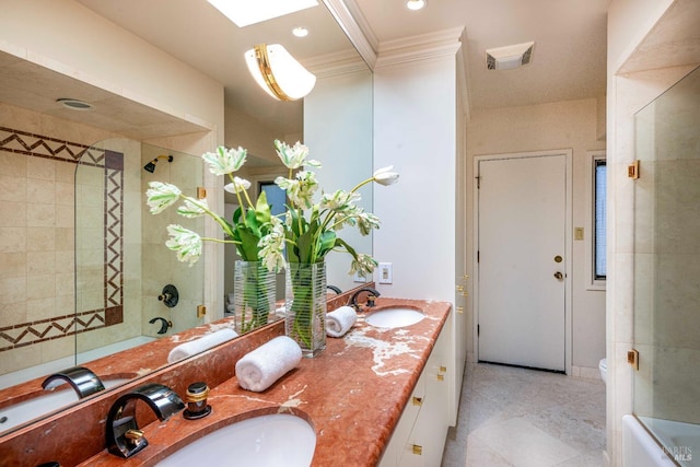 bathroom with double vanity, visible vents, toilet, and a sink