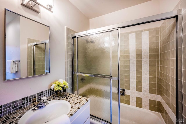 bathroom with enclosed tub / shower combo and a sink