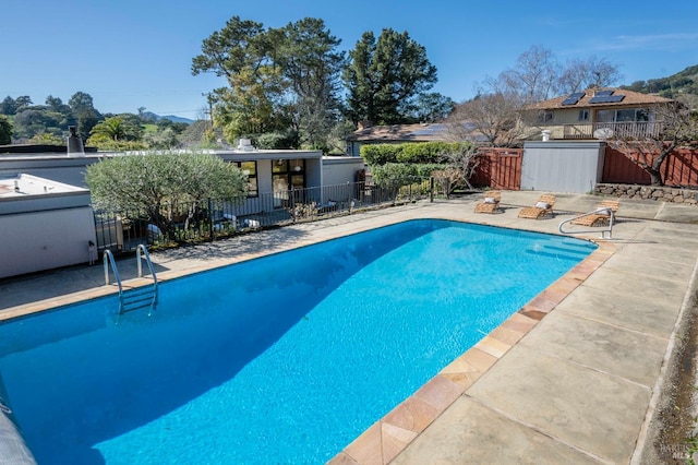 view of swimming pool featuring a patio area, fence, and a fenced in pool