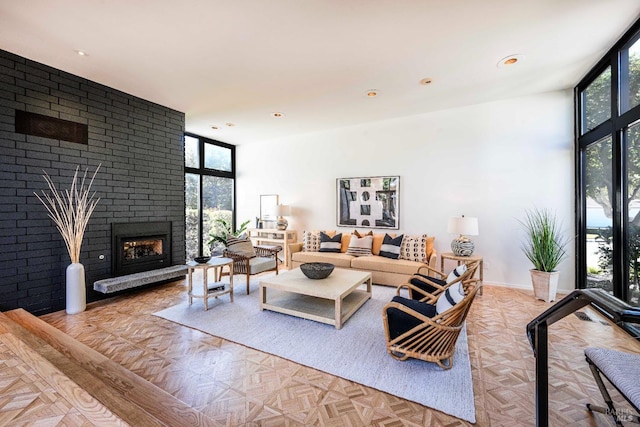 living area with a wall of windows, a wealth of natural light, and a brick fireplace