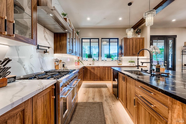 kitchen featuring glass insert cabinets, double oven range, a sink, and ventilation hood