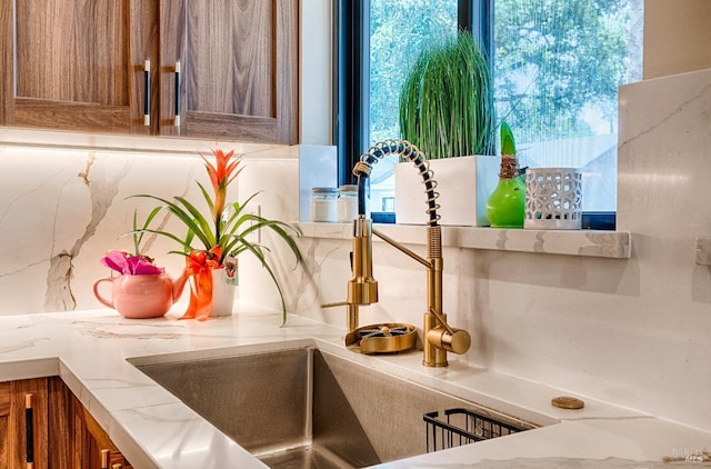 details featuring brown cabinetry, a sink, and tasteful backsplash