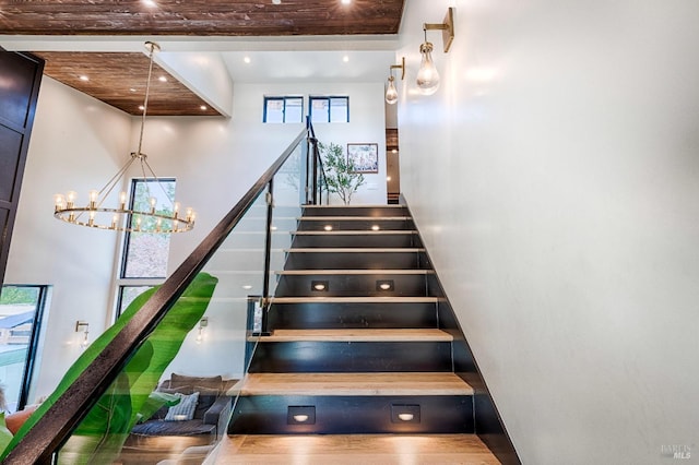 stairs with a high ceiling, a chandelier, and recessed lighting