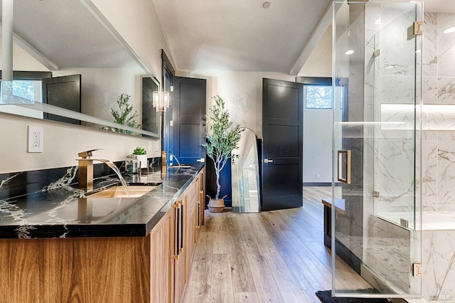 kitchen featuring light wood-style flooring, brown cabinets, dark stone countertops, open shelves, and a sink