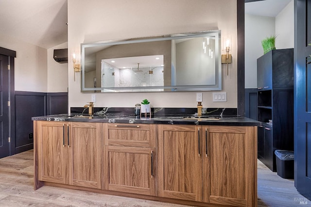 kitchen with dark countertops, brown cabinetry, and wainscoting