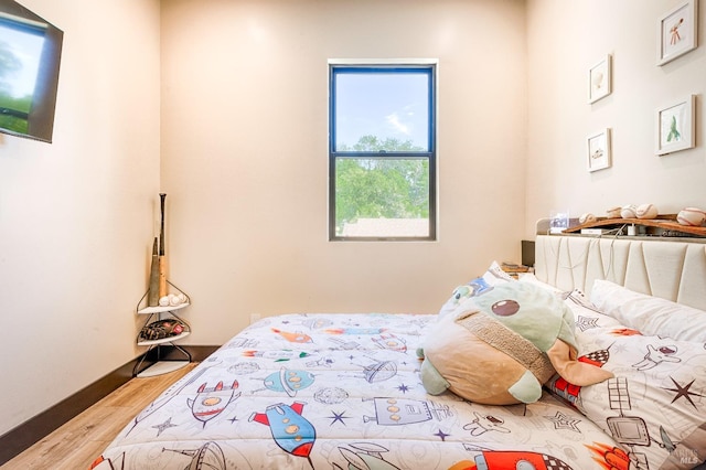 bedroom with wood finished floors and baseboards