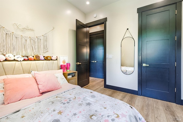 bedroom with light wood-style flooring, baseboards, and recessed lighting