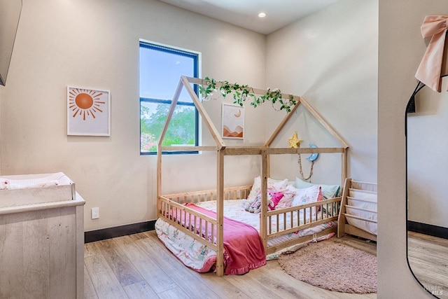 bedroom with light wood-type flooring and baseboards