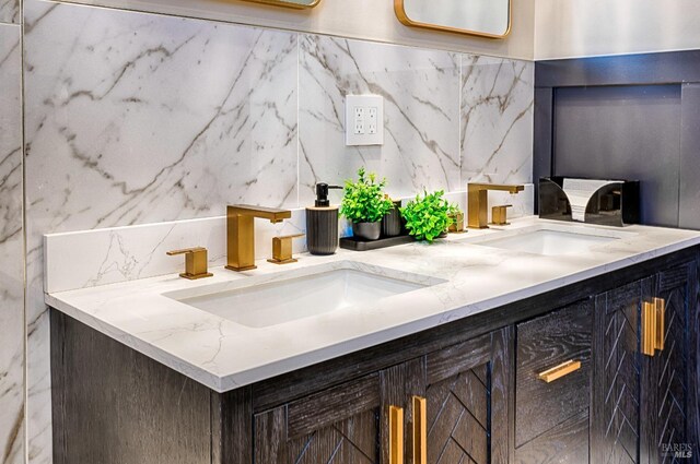 bathroom featuring double vanity, tasteful backsplash, and a sink