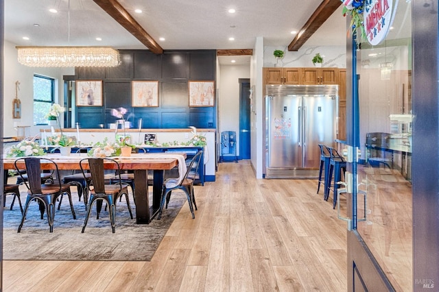 dining space with light wood finished floors, beam ceiling, and recessed lighting