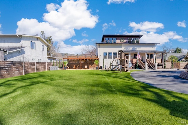 back of property featuring a yard, stairway, and fence