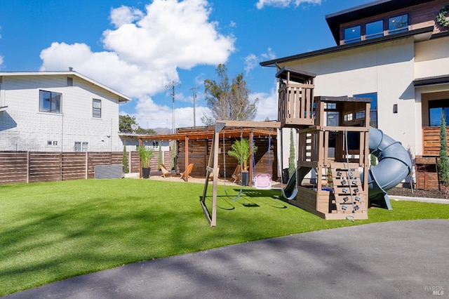 view of playground with a yard and fence