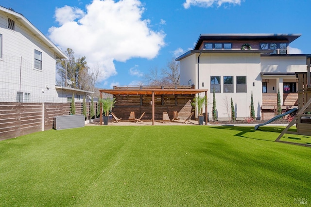 back of house featuring fence, a lawn, and stucco siding