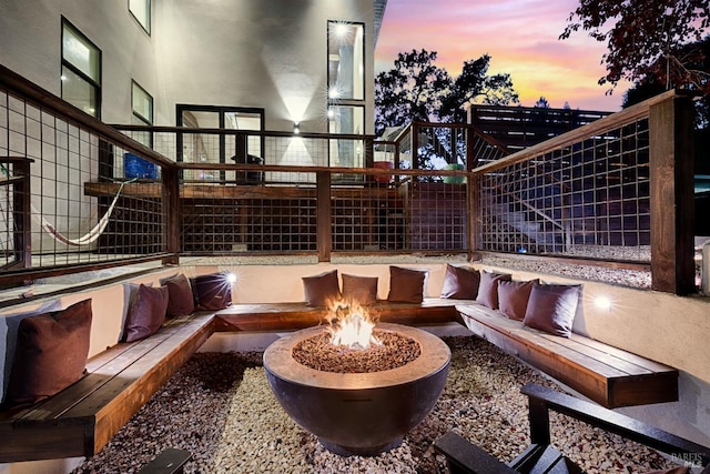 patio terrace at dusk featuring an outdoor living space with a fire pit