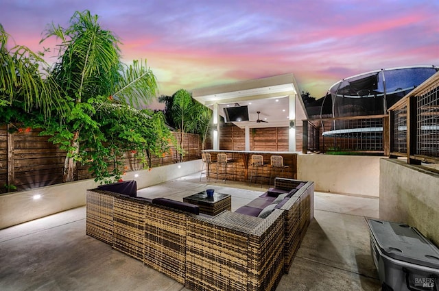 view of patio featuring a fenced backyard, a trampoline, outdoor lounge area, and an outdoor bar