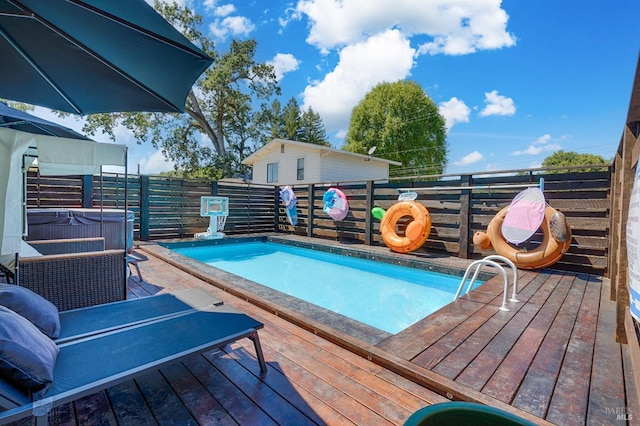 view of swimming pool featuring a deck and a fenced in pool