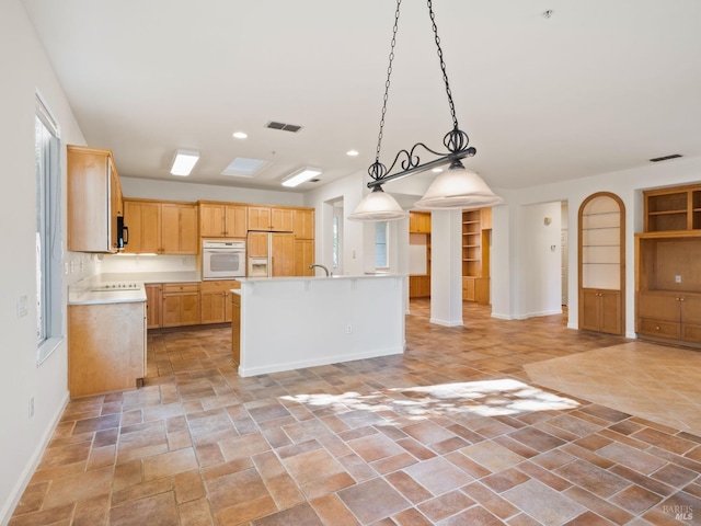 kitchen with white oven, light countertops, visible vents, open floor plan, and paneled fridge