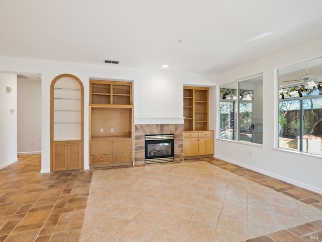 unfurnished living room featuring built in shelves, visible vents, and baseboards