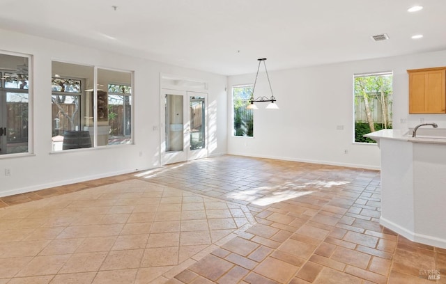 unfurnished dining area with visible vents, baseboards, a sink, and recessed lighting