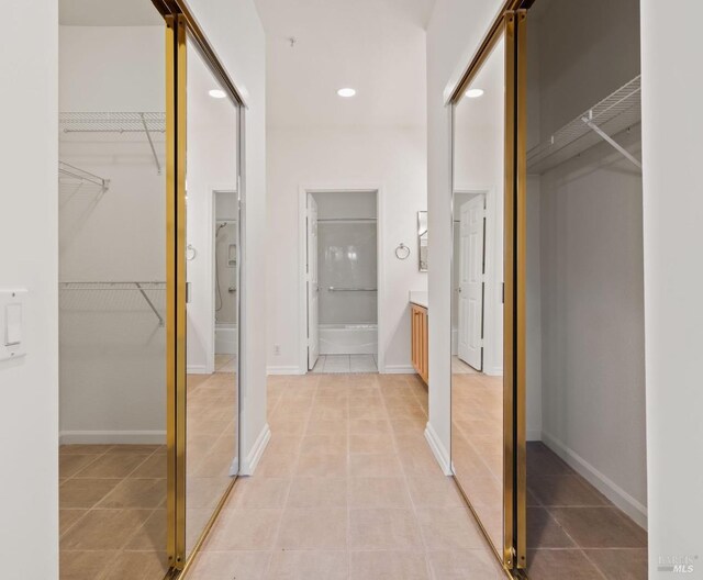 corridor with light tile patterned floors, baseboards, and recessed lighting