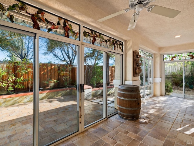 unfurnished sunroom featuring ceiling fan