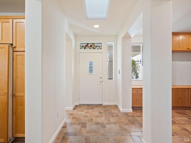 entrance foyer featuring stone finish flooring and baseboards