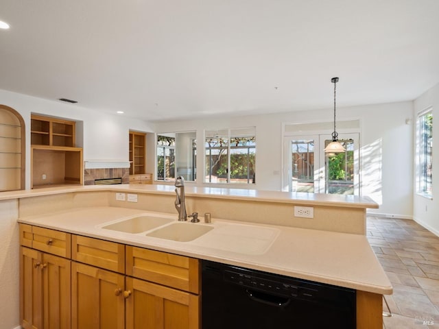 kitchen featuring black dishwasher, stone tile floors, open floor plan, light countertops, and a sink