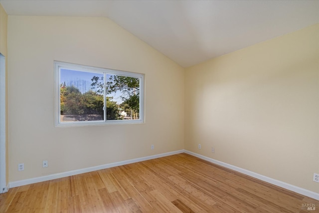 unfurnished room featuring light wood-style floors, vaulted ceiling, and baseboards